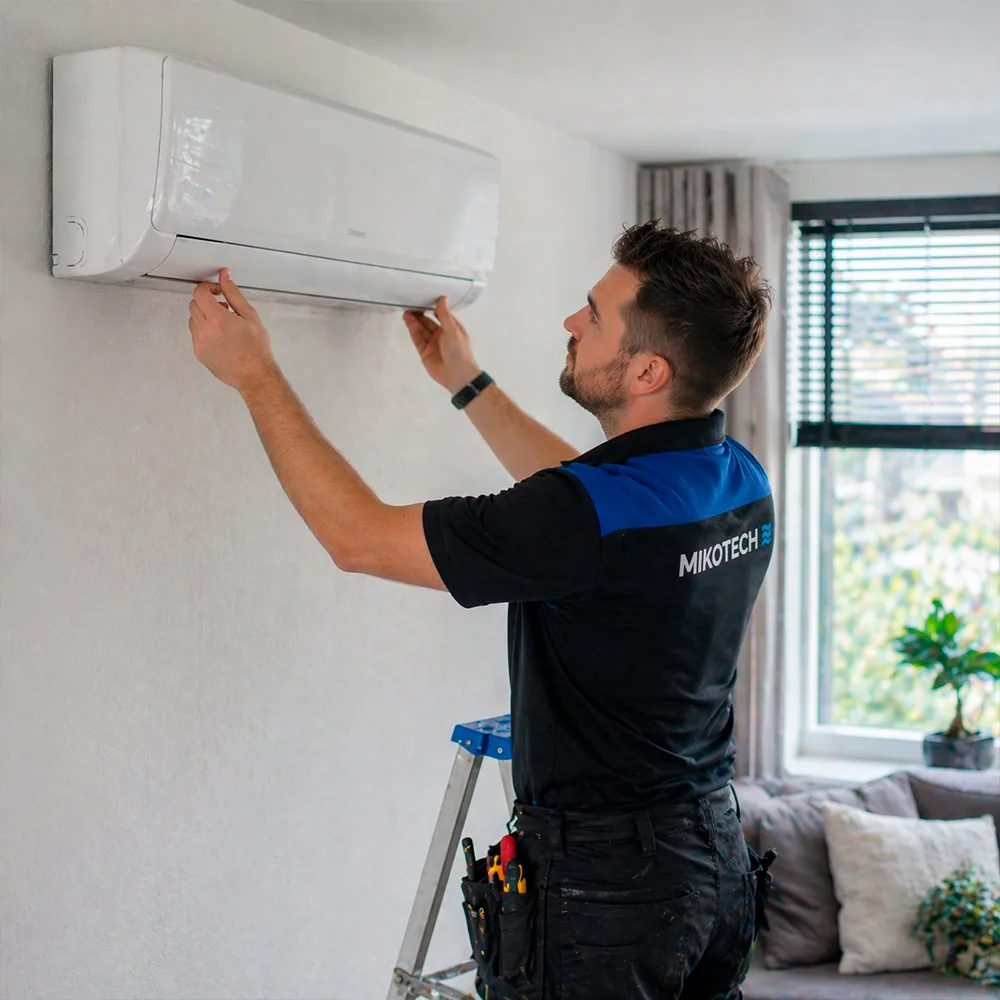 Mikotech monteur opent airco unit binnen voor reparatie in woning